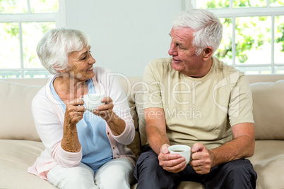 Senior man and woman sitting on sofa