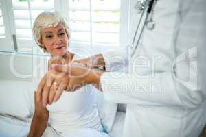 Midsection of doctor assisting senior woman
