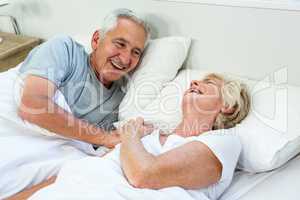 High angle view of smiling senior couple on bed