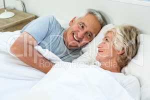 High angle view of senior couple relaxing on bed