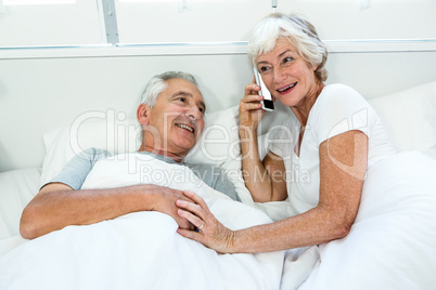 High angle view of senior woman with man talking on phone