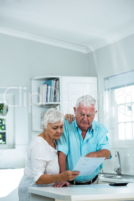 Senior couple reading document at home