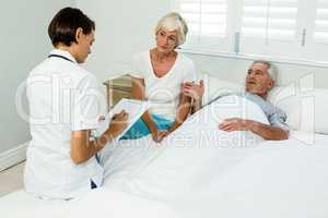 Female caregiver assisting senior man at home