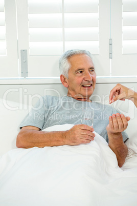 Cropped image of doctor giving medicine to old man