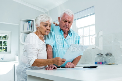 Senior couple calculating finances at home