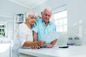 Senior couple calculating finances at home