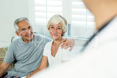 Smiling senior couple with doctor at home
