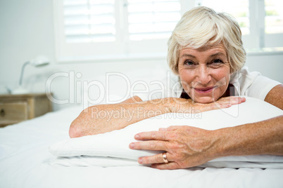 Portrait of smiling woman relaxing on bed