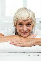 Portrait of smiling senior woman on bed