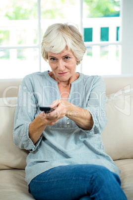 Senior woman operating remote control