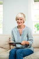Portrait of smiling senior woman with digital tablet