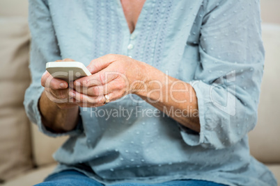 Midsection of senior woman using mobile phone