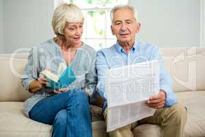 Senior couple reading newspaper at home