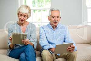 Senior couple using digital tablet at home