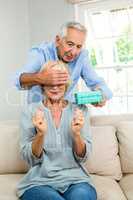 Senior man gifting woman at home