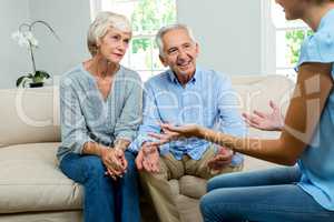 Female consultant explaining senior couple at home