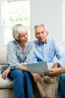 Cropped image of consultant showing report to senior couple