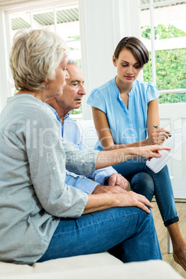 Aged couple reading report with female consultant
