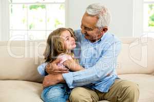 Smiling granddad hugging girl