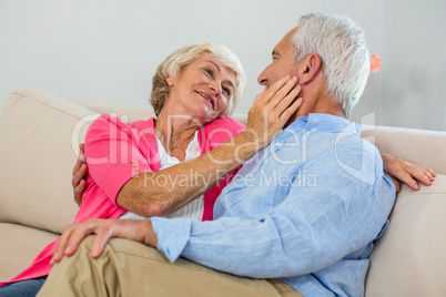 Romantic retired couple sitting on sof