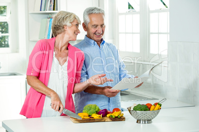 Smiling senior couple with recipe book