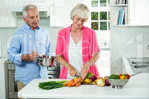 Happy senior couple preparing vegetables