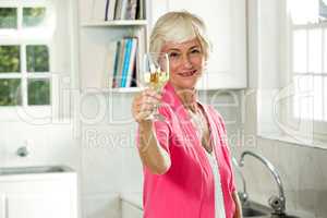 Portrait of happy senior woman holding white wine