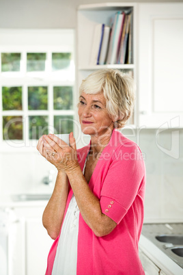 Thoughtful senior woman holding coffee cup