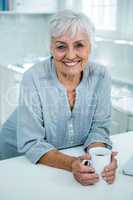 Portrait of smiling senior woman with coffee mug