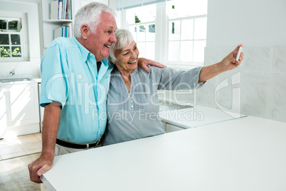 Happy senior couple taking selfie at home