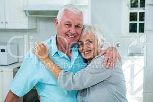 Affectionate senior couple embracing at home