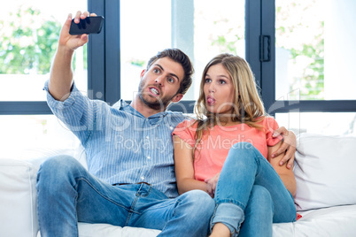 Young couple making faces while taking selfie