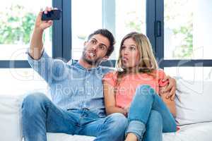 Young couple making faces while taking selfie