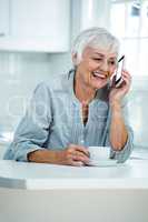 Happy retired woman talking on phone