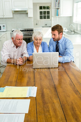 Agent talking to senior couple while sitting
