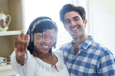 Happy young couple showing a key of their new house