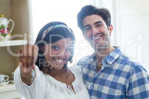 Happy young couple showing a key of their new house