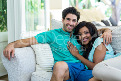 Portrait of happy young couple embracing each other on sofa