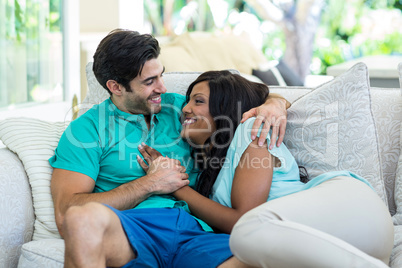 Happy young couple embracing each other on sofa