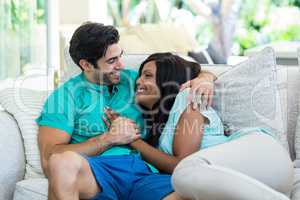 Happy young couple embracing each other on sofa