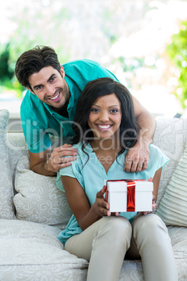 Man and woman on a sofa with a gift