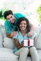 Man and woman on a sofa with a gift