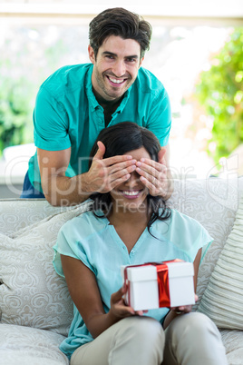 Man giving a surprise gift woman