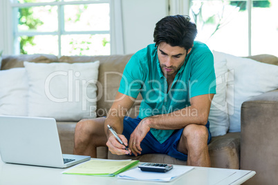 Man with laptop accounting the bills