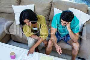 Worried young couple discussing on bills