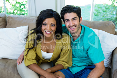 Portrait of young couple sitting on sofa