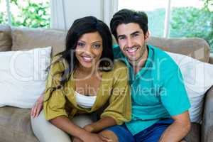 Portrait of young couple sitting on sofa