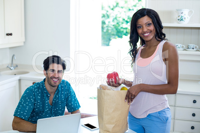 Woman standing with a bag of groceries
