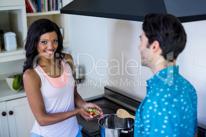 Young couple cooking food together in kitchen