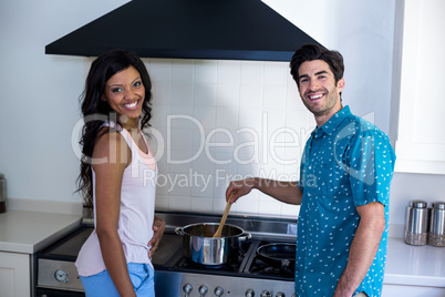 Portrait of couple cooking food together in kitchen
